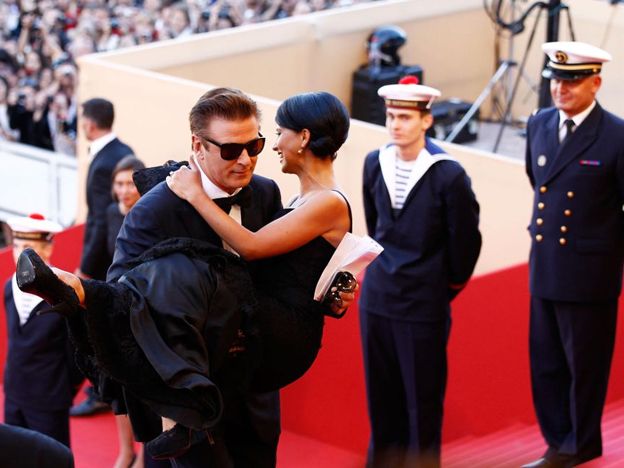 Alec Baldwin lleva en brazos a Hilaria Thomas por las escaleras del Palais de Festivals de Cannes.