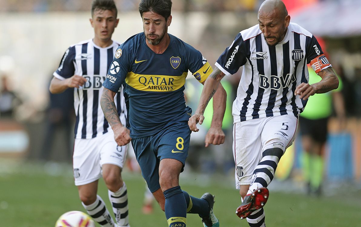 Talleres midfielder Pablo Guinazu (R) kicks the ball next to Boca Juniors midfielder Pablo Perez (C) during an Argentinian First Division Superliga football match at La Bombonera stadium, in Buenos Aires, on August 12, 2018. (Photo by ALEJANDRO PAGNI / AFP)