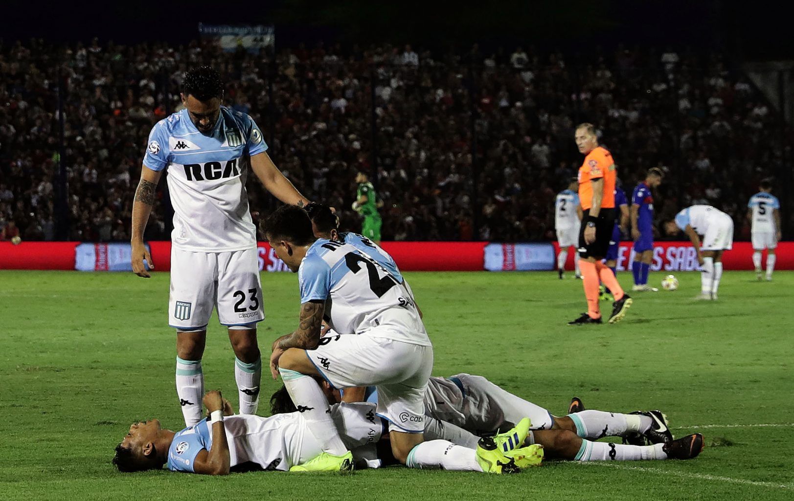 Racing Club’s midfielder Augusto Solari (hidden) celebrates with teammates after scoring a goal against Tigre, during their Argentina First Division Superliga football match at Coliseo stadium, in Victoria, Buenos Aires province, Argentina on March 31, 2019. – Racing tied 1-1 against Tigre and obtained the Superliga victory. (Photo by ALEJANDRO PAGNI / AFP)