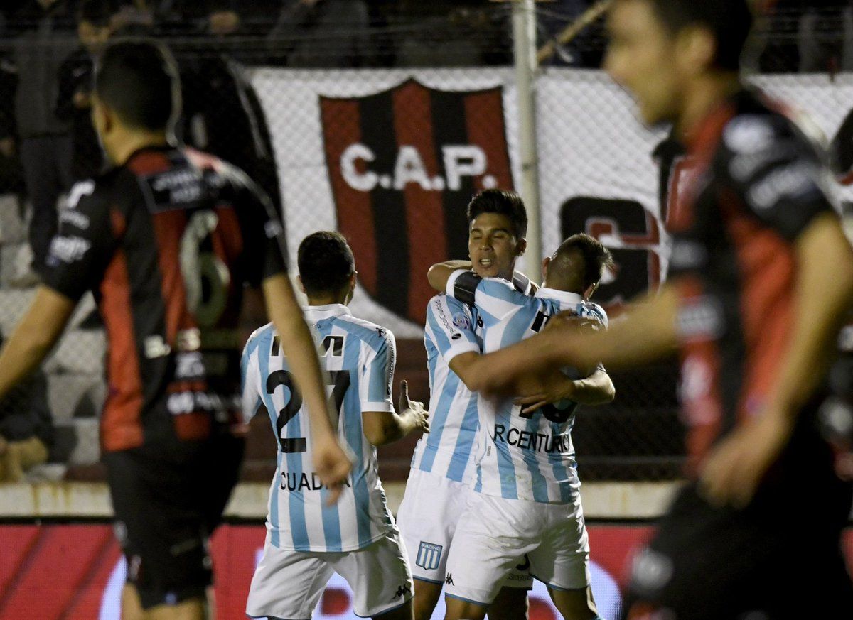 Racing Clubs midfielder Augusto Solari (hidden) celebrates with teammates after scoring a goal against Tigre, during their Argentina First Division Superliga football match at Coliseo stadium, in Victoria, Buenos Aires province, Argentina on March 31, 2019. - Racing tied 1-1 against Tigre and obtained the Superliga victory. (Photo by ALEJANDRO PAGNI / AFP)