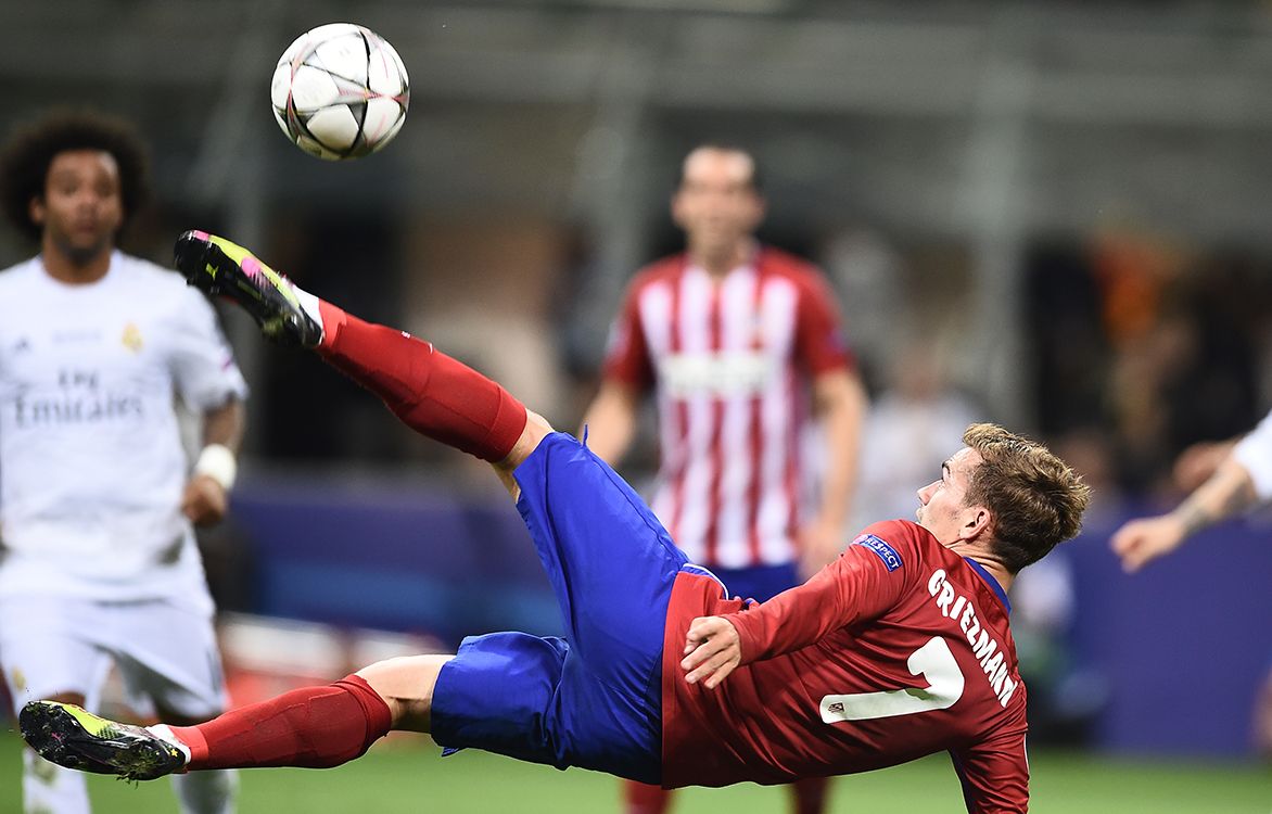 Atletico Madrids French forward Antoine Griezmann jumps for the ball during the UEFA Champions League final football match between Real Madrid and Atletico Madrid at San Siro Stadium in Milan, on May 28, 2016. (Photo by FILIPPO MONTEFORTE / AFP)