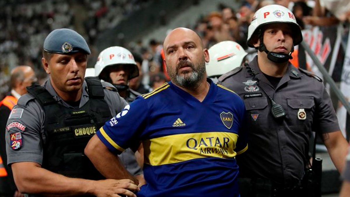 El hincha de Boca escoltado por la policía brasileño.