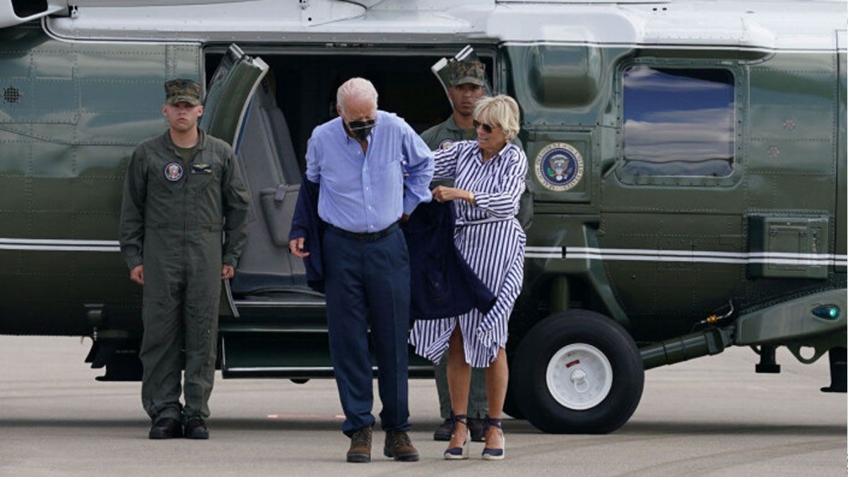 Joe Biden tiene que ser asistido por su esposa Jill Biden para poder colocarse su saco por una brisa en el aeropuerto de Kentucky (Foto: C-SPAN)