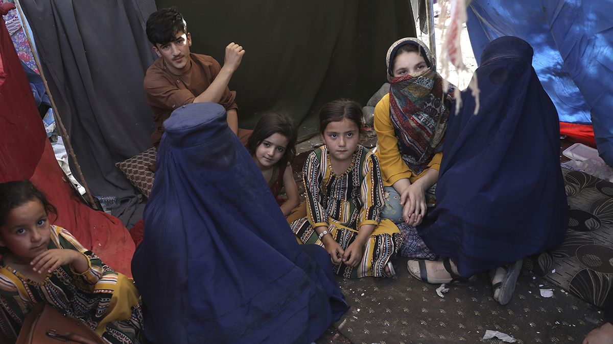 En esta fotografía del 13 de agosto de 2021, una profesora desplazada (izquierda), quien porta una burka y se identificó con su nombre Nilofar, habla con The Associated Press durante una entrevista en el interior de su tienda de campaña en un parque público de Kabul, Afganistán. (AP Foto/Rahmat Gul, Archivo)