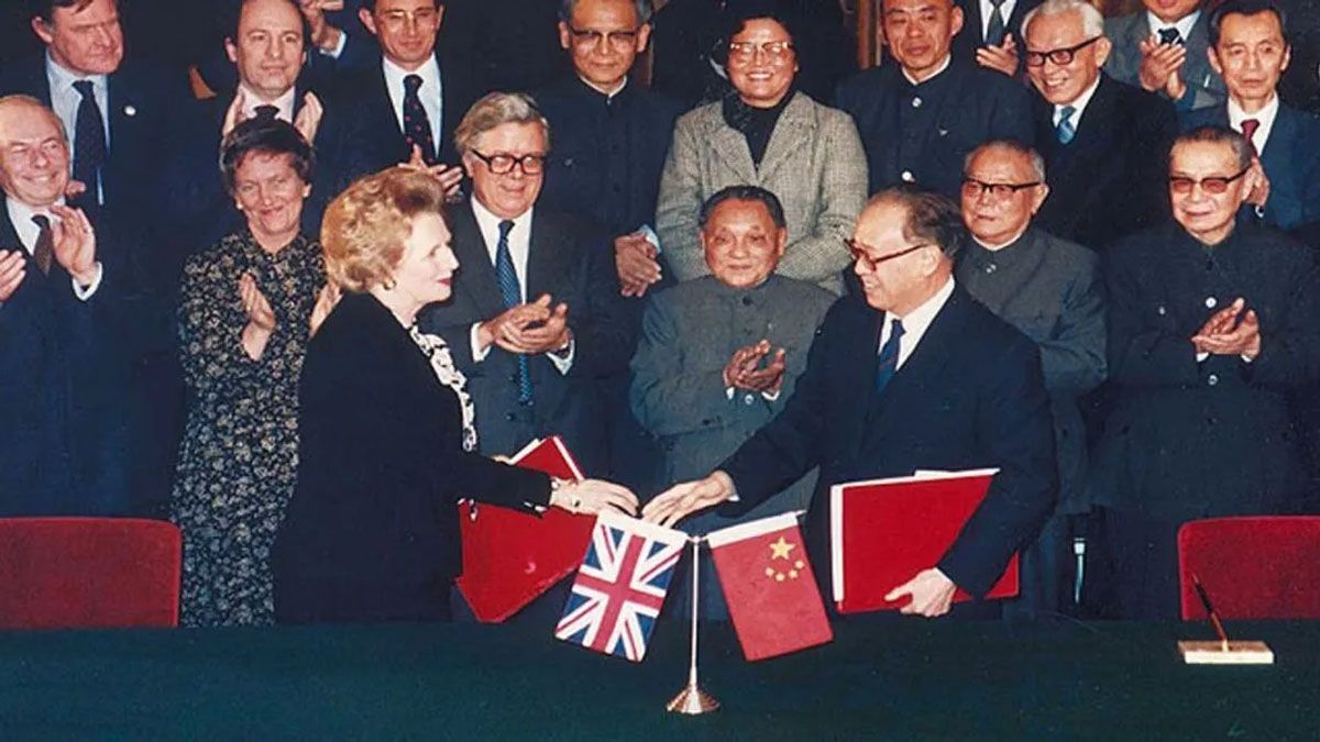 Margaret Thatcher y el acta por el cual se cede la soberanía de Hong Kong a China en  un plazo de 50 años. Deng Xiaoping aplaude en segundo plano (Foto: Archivo)