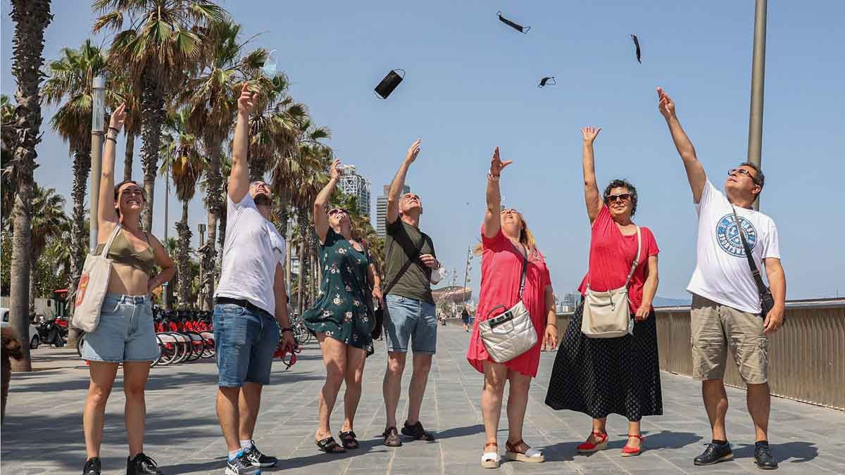 Españoles celebran arrojando al aire los barbijos. Ya no es obligatorio su uso en la mayoría de los espacios cerrados (Foto. Gentileza El Periódico)