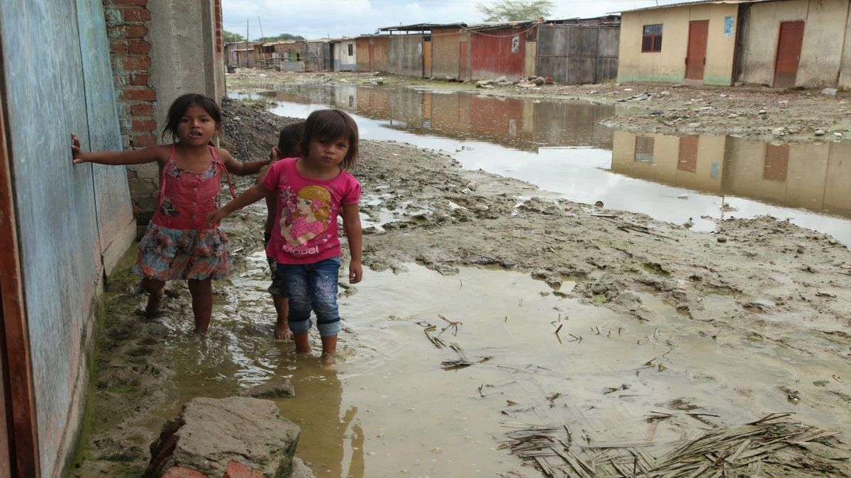 Niños se desplazan en un deprimido suburbio peruano luego de una intensa lluvia. Centenares de millones de niños y niñas en todo el planeta viven bajo la amenaza de inundaciones