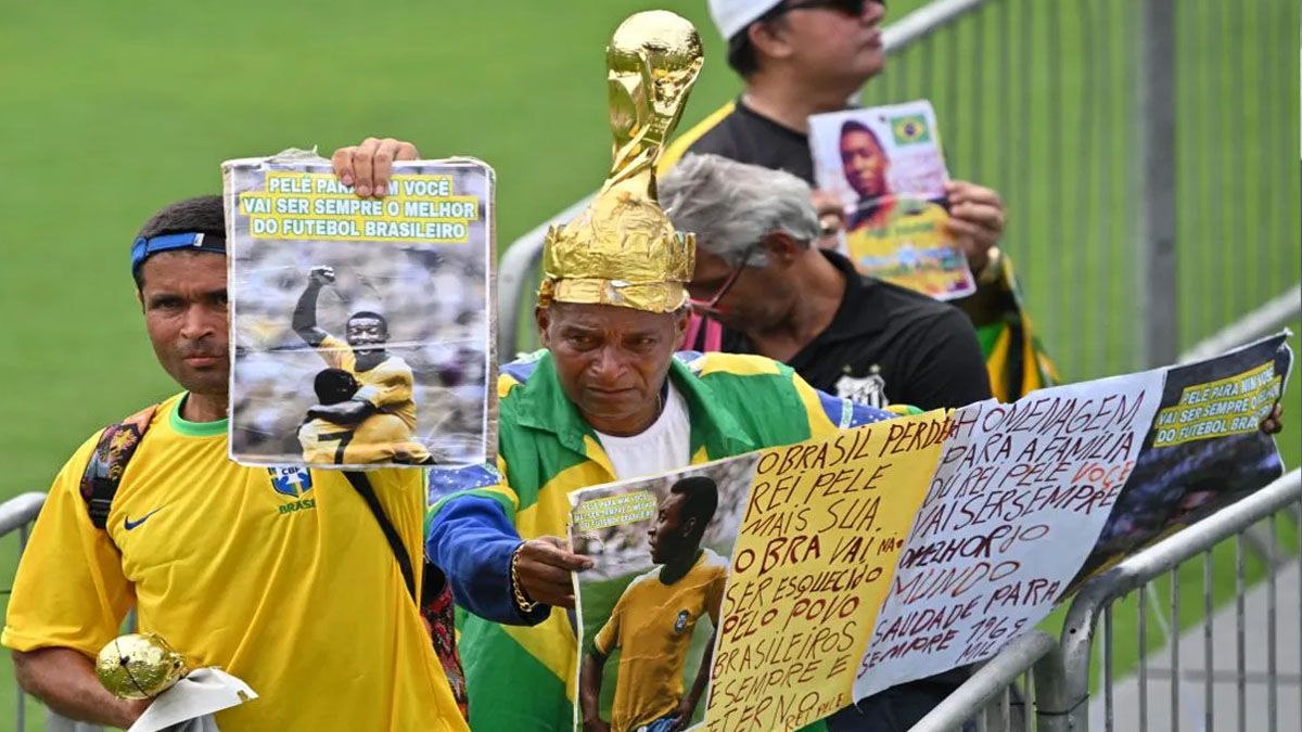 Los fans de Pelé, con mensajes, fotos y hasta copas del mundo sobre sus cabezas para despedir a la leyenda. (Foto: Captura de TV)