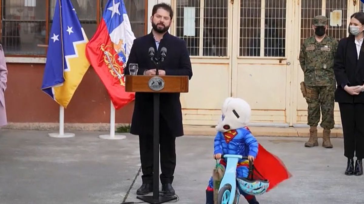 Un pequeño disfrazado de Superman observa con atención al presidente de Chile