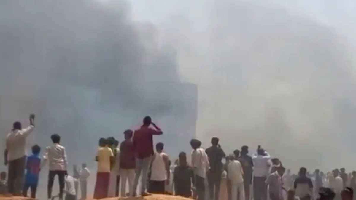 Un grupo de personas mira la nube de humo negro del avi&oacute;n de Air India. Cay&oacute; y destruy&oacute; viviendas pegadas al aeropuerto (Foto: Reuters).