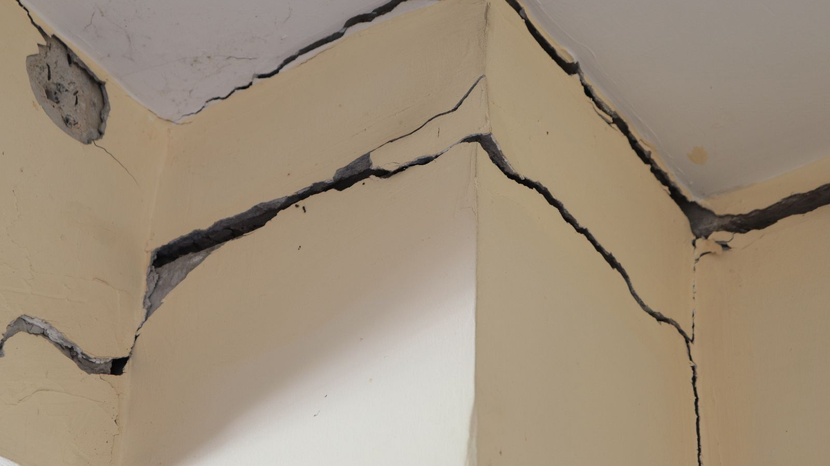 Una grieta fina recorriendo la pared de una habitación vacía