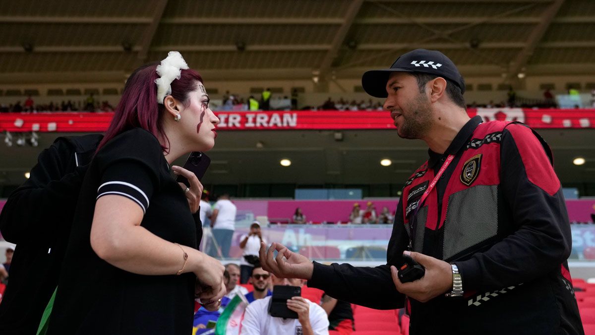 un guardia qatarí obliga a que la manifestante iraní se retire del estadio (Foto: AP)