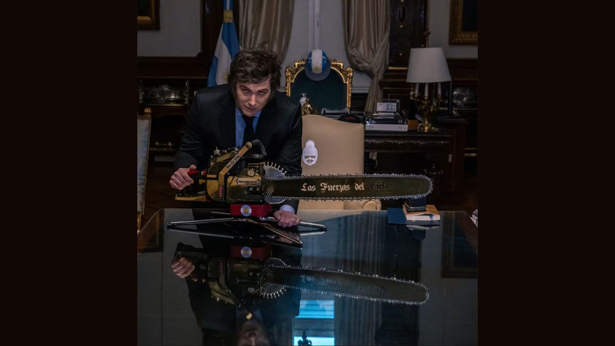 Javier Milei, con motosierra y su mesa de gobierno. En la entrevista del Wall Street Journal. (Foto: WSJ)
