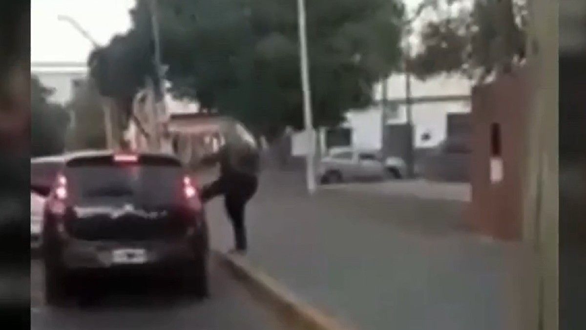 El violento momento e que el hombre ataca a patadas el vehículo. 