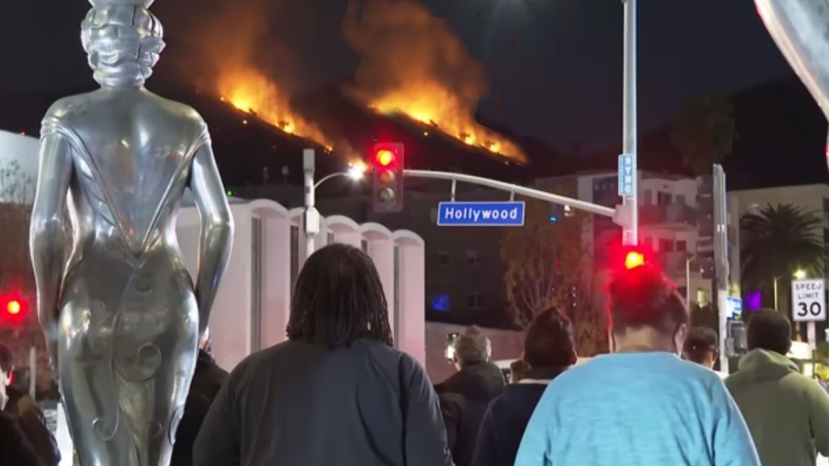 La gente mira el fuego que baja peligrosamente hacia el 