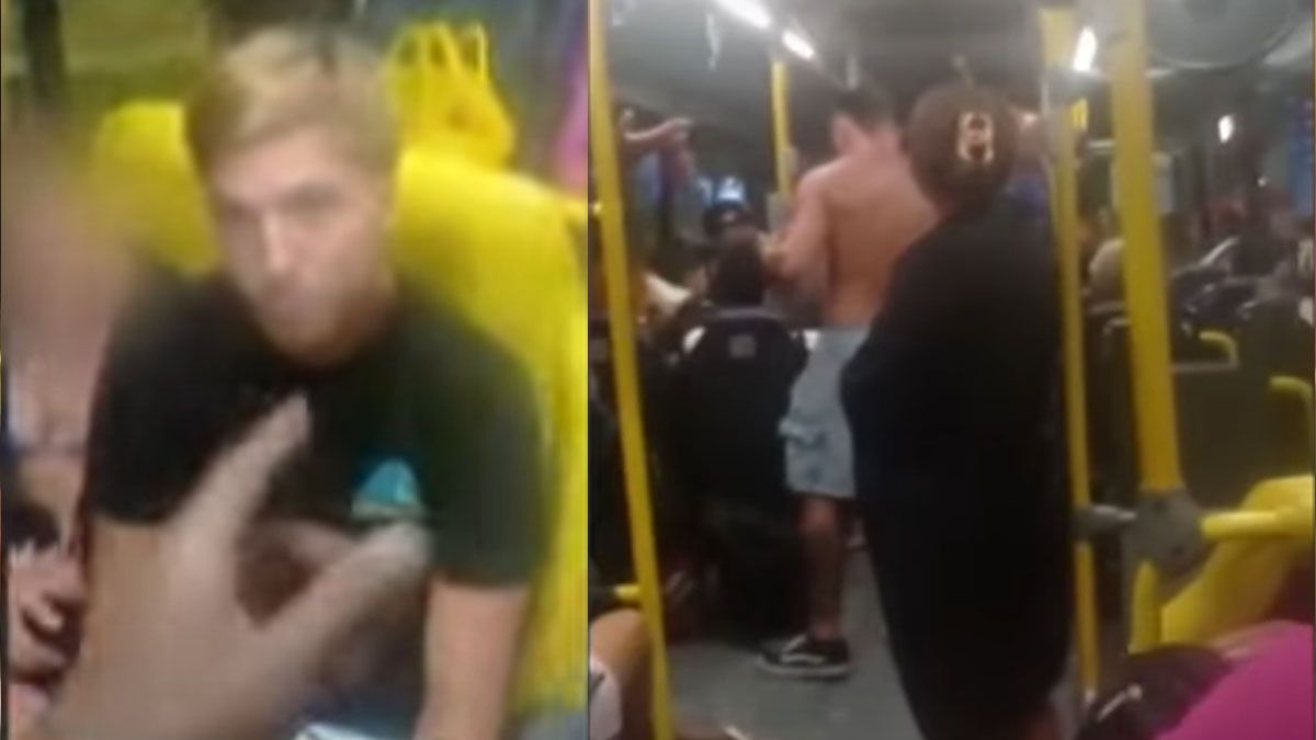 Uno de los pasajeros del colectivo señala mientras graba con su celular al argentino acusado de proferir inultos racista en Brasil. (Foto: Captura de TV) 