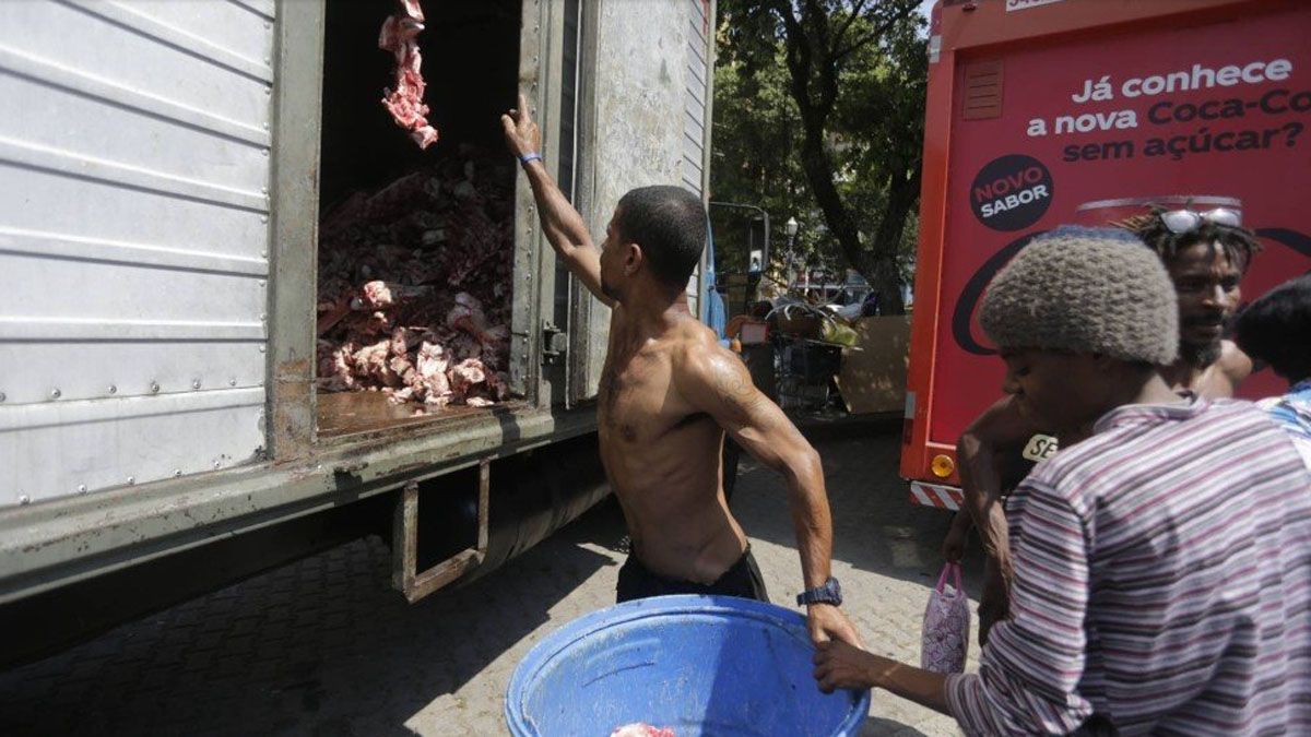 Todos los días se repite esta escena: gente que recibe restos de carne vacuna para ser desechada. Es lo único que consiguen para comer (Foto: EXTRA)