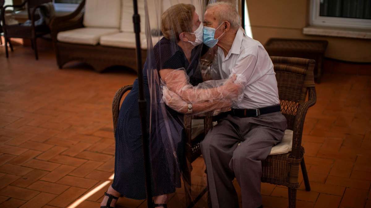 Tras 3 meses separados, una pareja de ancianos se besa a través de tela de plástico