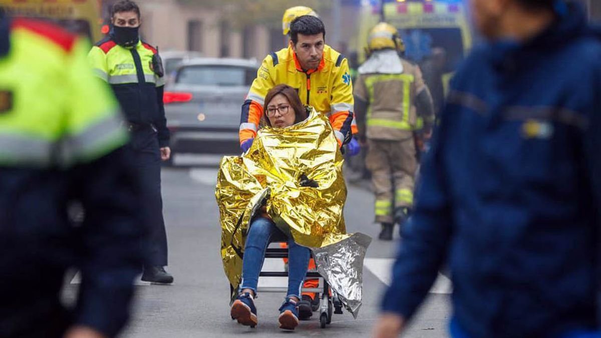 Los bomberos asisten a los heridos por el choque de trenes en Barcelona. (Foto: Télam)