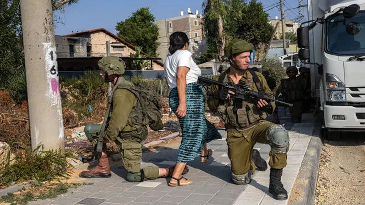 Una mujer entre soldados de Israel tras el ataque de Hamas con misiles a Tel Aviv. (Foto: Gentileza Times of Israel)