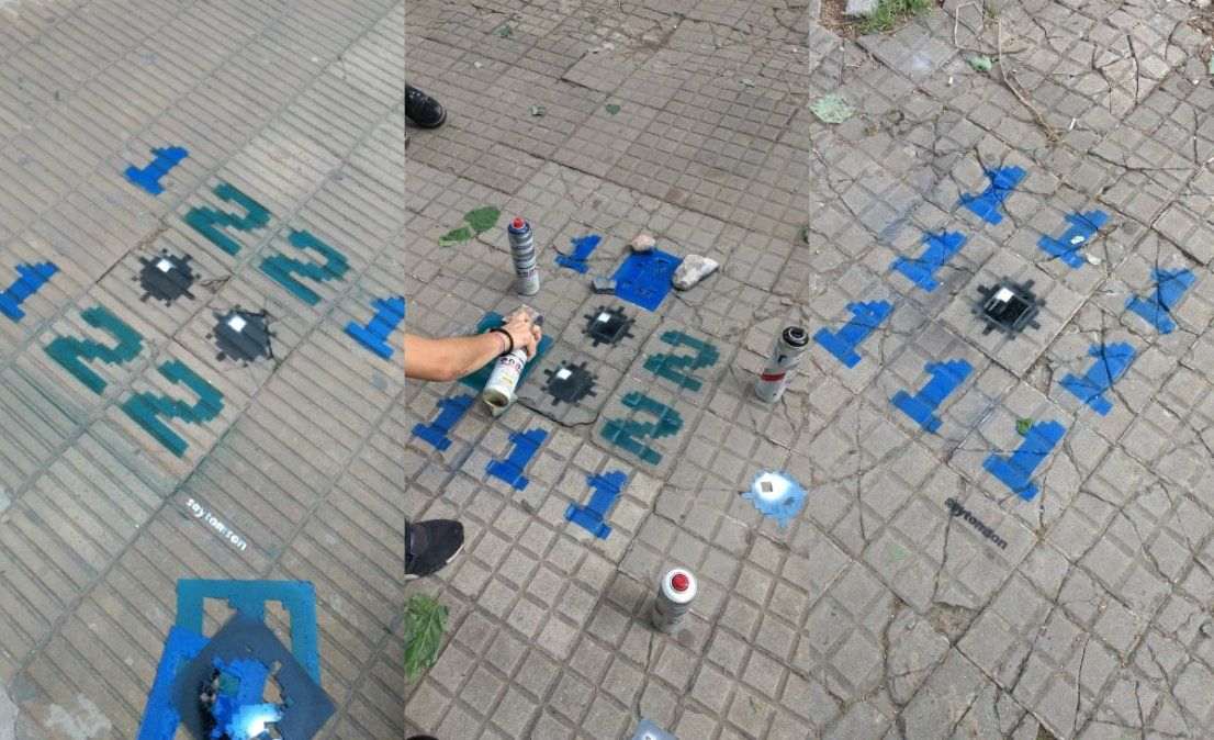 Un artista pinta bombas del Buscaminas sobre las baldosas flojas de las veredas de La Plata