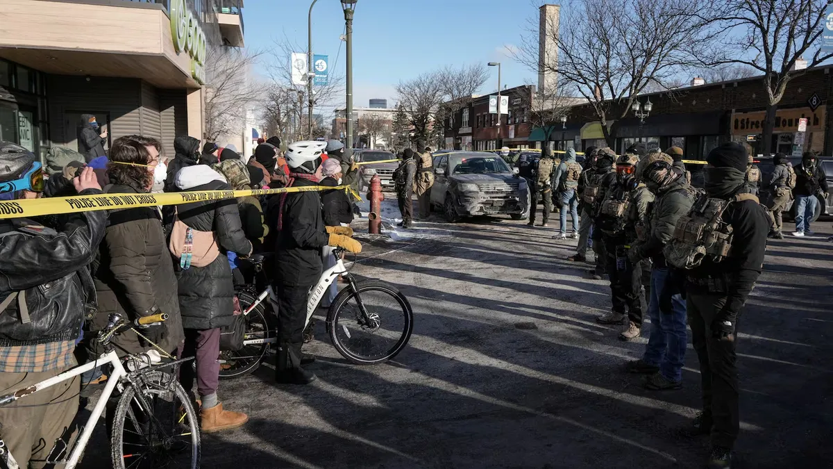 Una multitud se congreg&oacute; detr&aacute;s de la cinta de acordonamiento en el lugar del tiroteo.&nbsp;