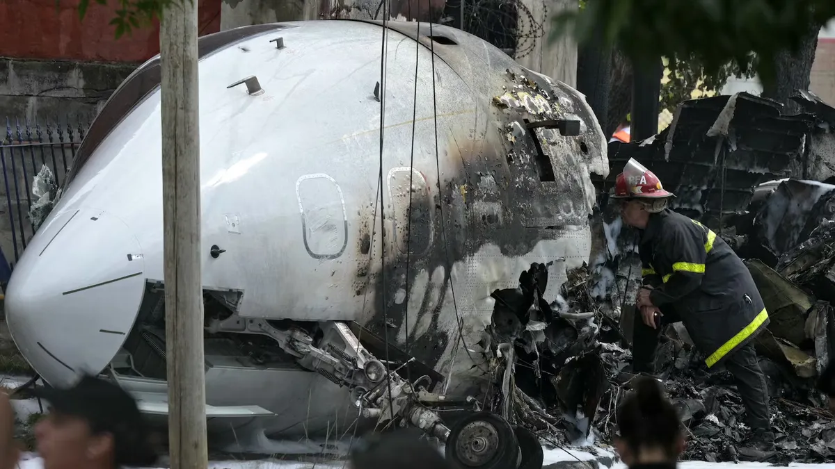 Un bombero inspecciona los restos del Challenger 300 que se estrelló en San Fernando. (Foto: AFP)