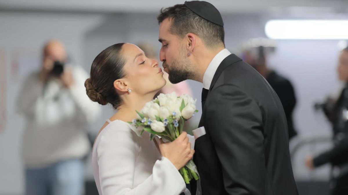 El beso matrimonial en un garage subterráneo, convertido en un salón improvisado para celebrar una boda y luego la fiesta de casamiento. (Foto: Instagram)