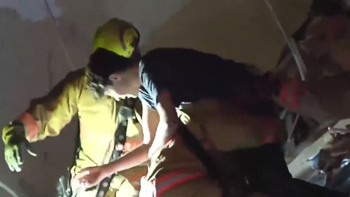 El momento en que los equipos de rescate sacan a un adolescente de los restos del edificio.