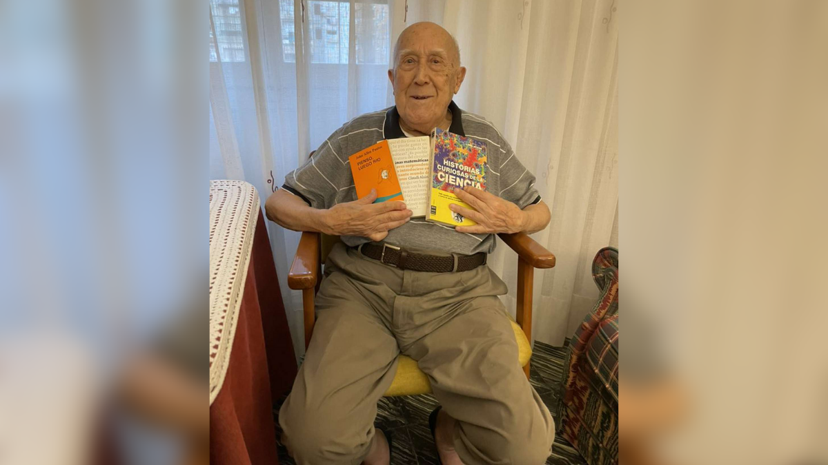 Juan, el abuelo de Cris, sosteniendo algunos libros.