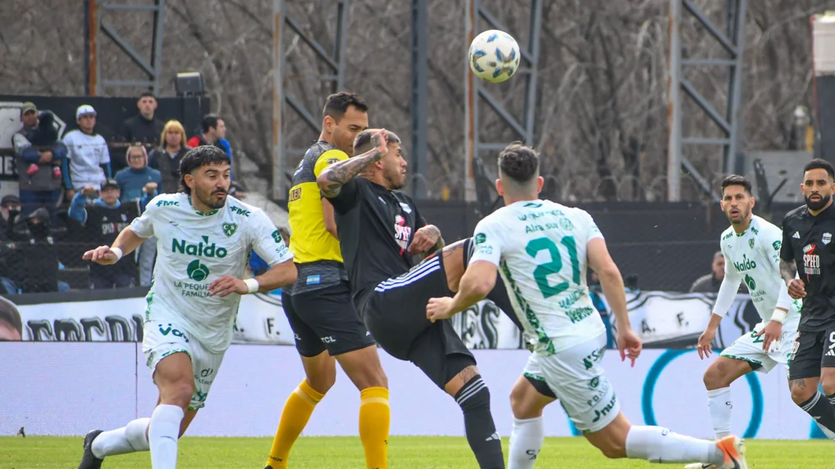 Milton Céliz disputa la pelota ante Emiliano Méndez. (Foto: NA)