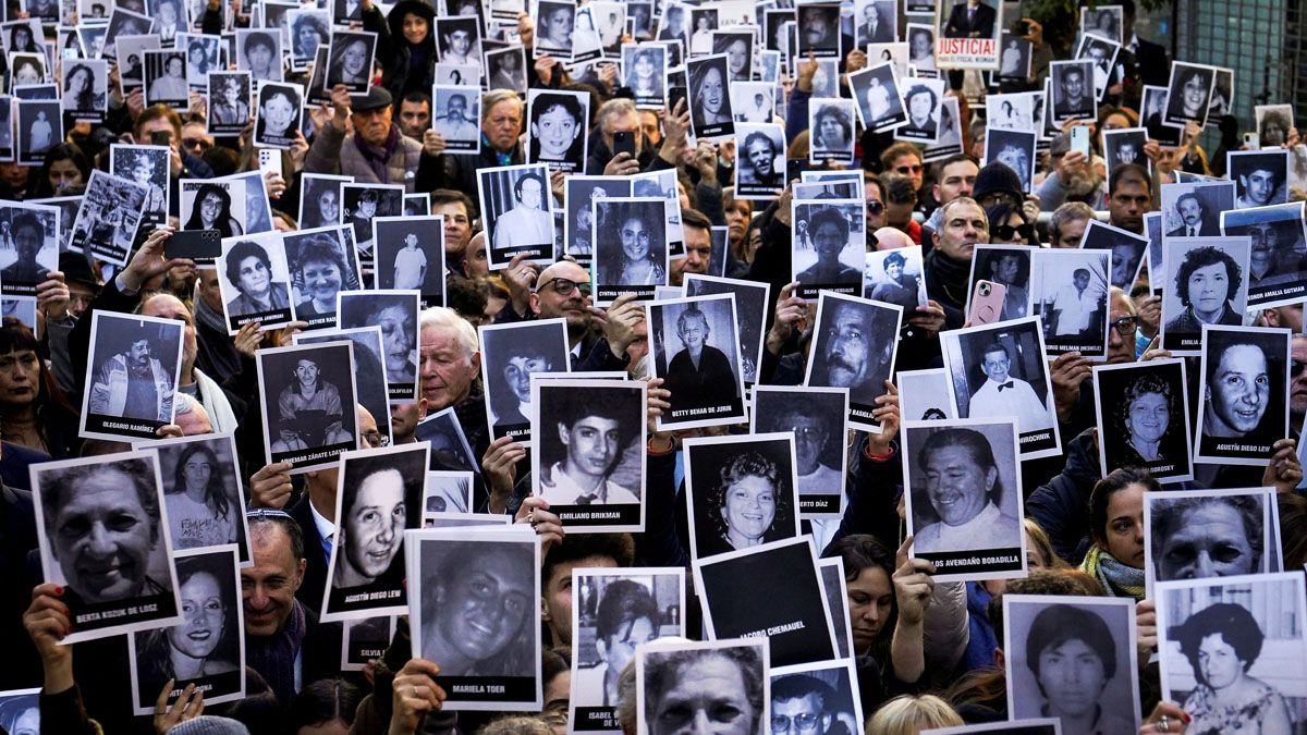 Los presentes en el acto, con los carteles de la cara de las víctimas del atentado. (Foto: Reuters) Los presentes en el acto, con los carteles de la cara de las víctimas del atentado. (Foto: Reuters)
