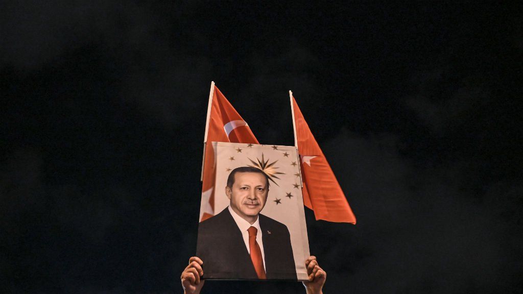 Un simpatizante alza una foto del presidente de Turquía Erdogan. El mandatario echó al titular del banco central turco Agbal por subir la tasa de interés. (Foto: AP)