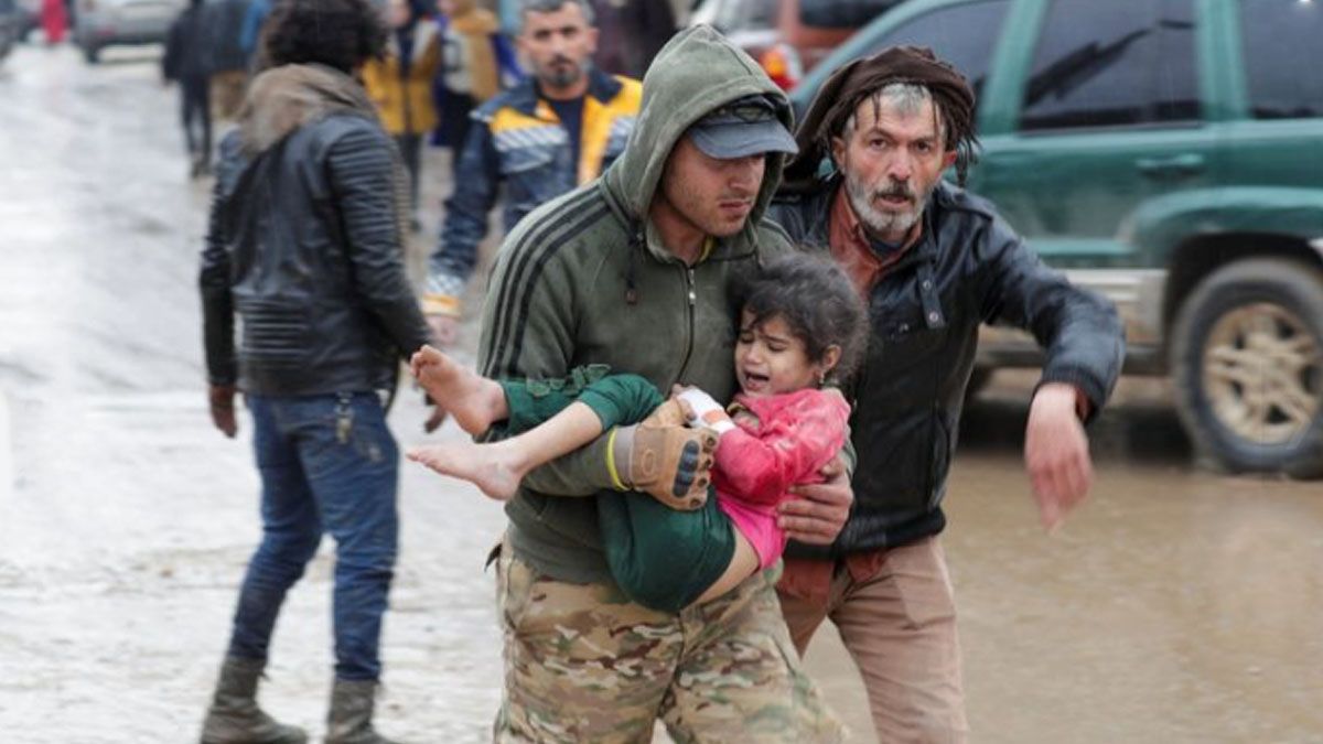 Dos rescatistas trasladan a un niño en Gaziantep, sacado de los escombros (Foto: Gentileza O Globo)