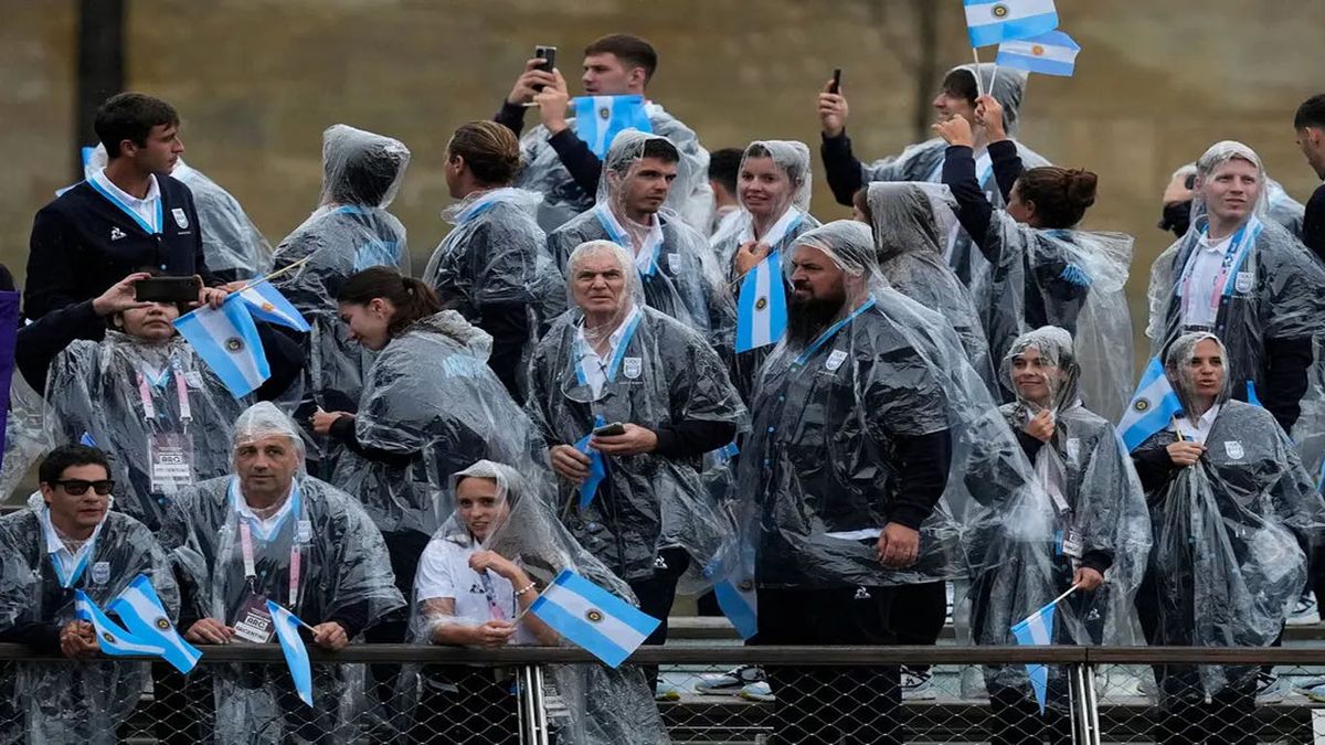 Bajo la lluvia, los atletas argentinos se presentan por el Sena. Los franceses, abuchean. (Foto: NYTimes)