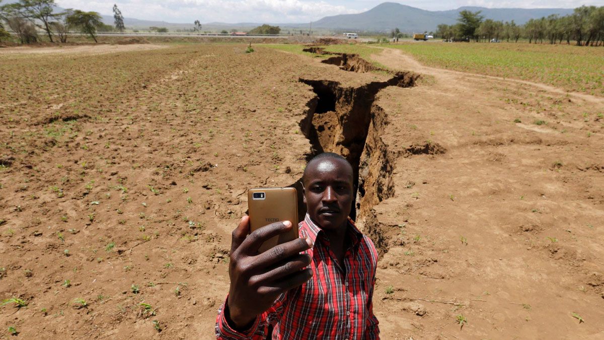 Un hombre se saca una foto delante de la enorme grieta que se abrió en África oriental. (Foto: Gentileza El Periódico)