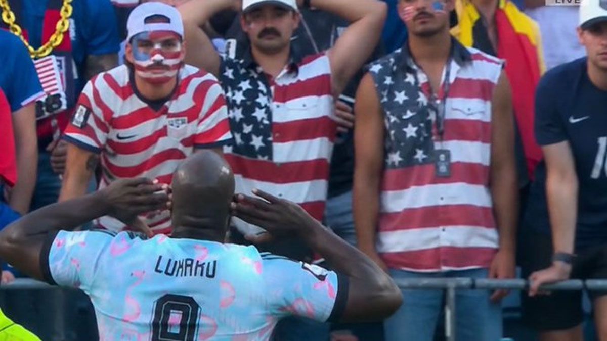 Lukaku se lleva las manos a las orejas. Como burlándose por el llamado de Trump. Los hinchas de EE.UU. observan desencantados. (Foto: 