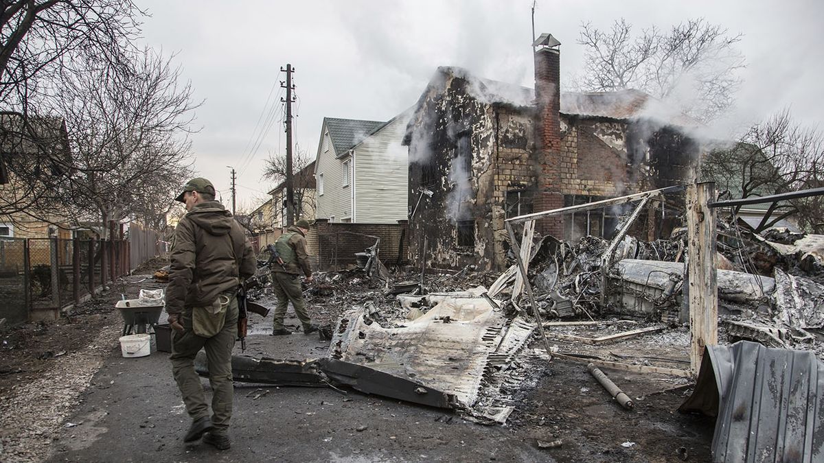 Un soldado ucraniano camina entre los restos de un avión derribado en Kiev