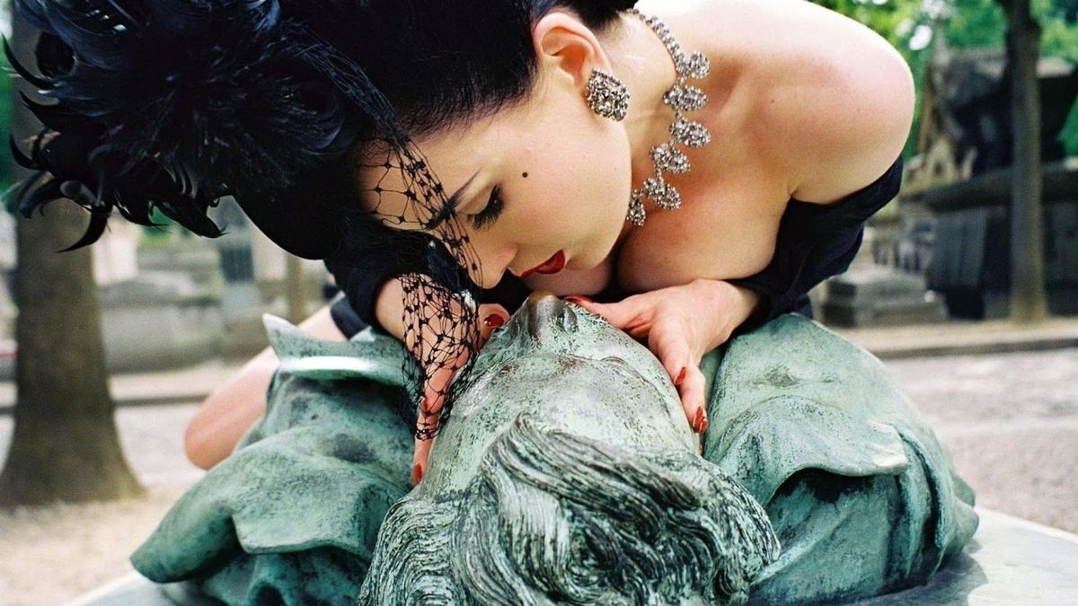 Una mujer cumple con el rito de besar en el boca la estatua de Victor Noir.
