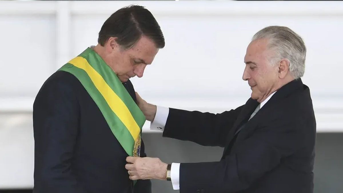 Michel Temer le coloca la banda presidencial a Jair Bolsonaro. Pero el presidente saliente no quiere hacer lo mismo con Lula (Foto: Gentileza O Globo)