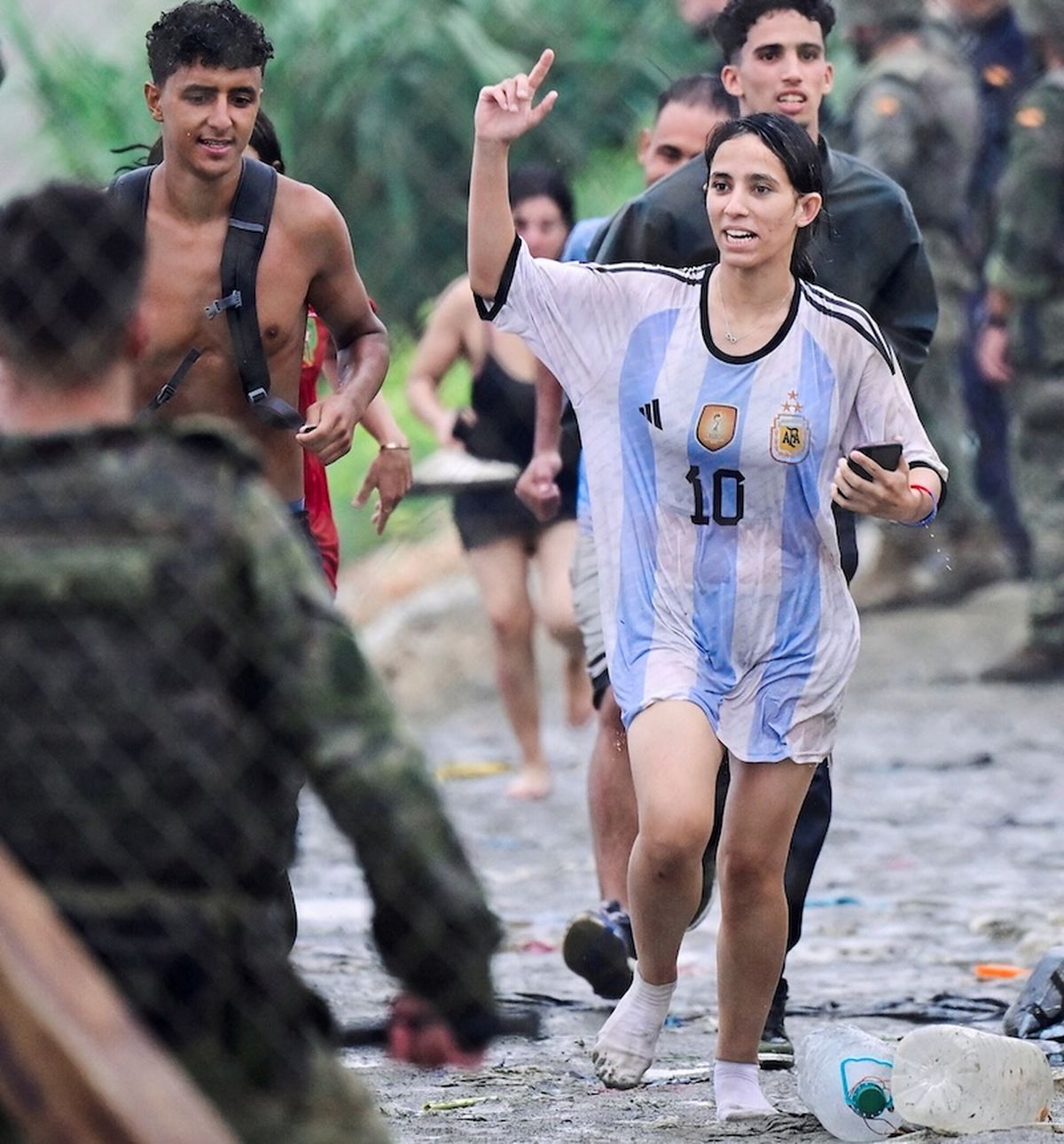 Una mujer corre junto con otros refugiados, mientras un grupo de soldados custodia la escena (Foto: Reuters).