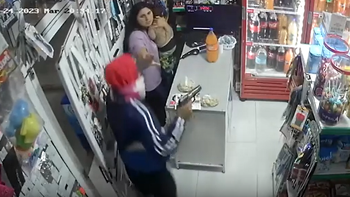 El ladrón apuntandole a la mujer y a su hijo. (Foto: captura) El ladrón apuntandole a la mujer y a su hijo. (Foto: captura)