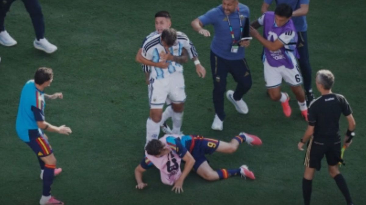 Paredes, sujetado por otro jugador argentino. En el piso, Gavi, el 9 del seleccionado español, uno de los suplentes del campeón. (foto: captura de Video/Reuters)
