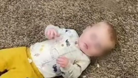 Madre hace comer a su bebé del piso como si fuera una gallina