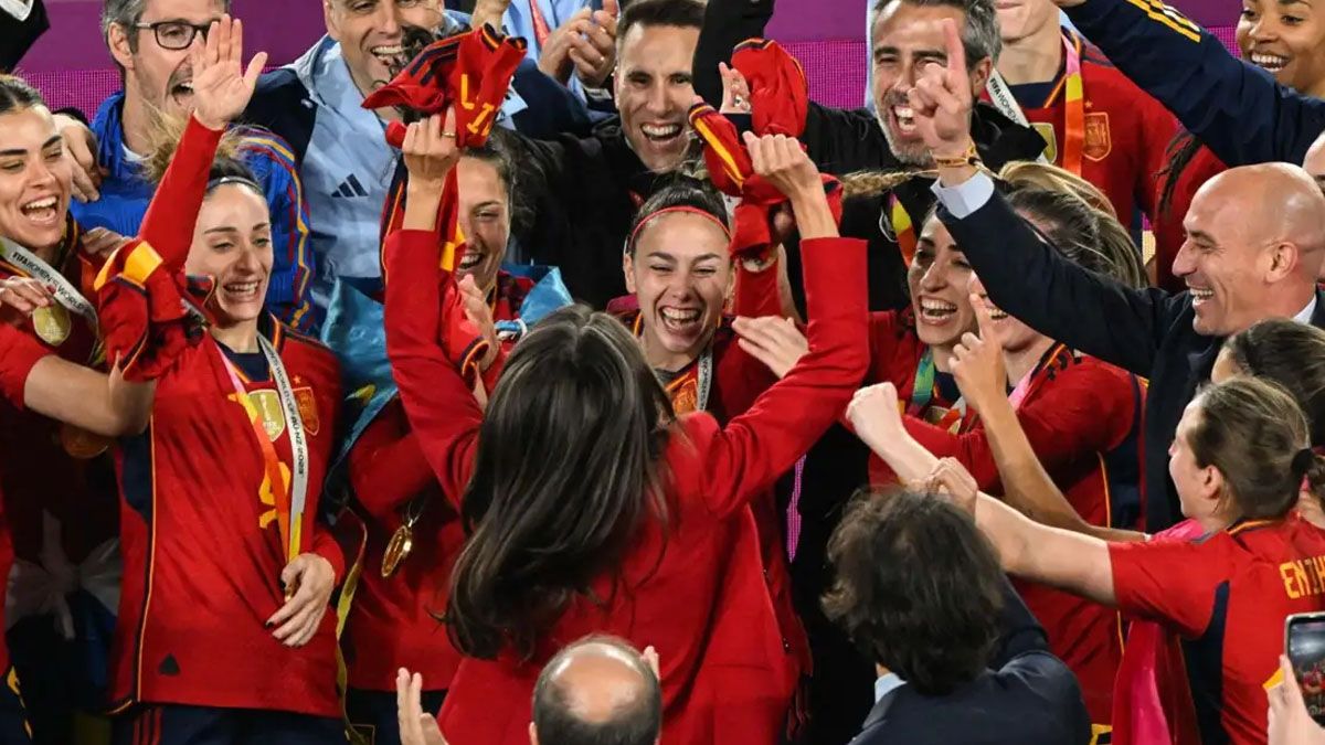 De espaldas, con la camiseta de España en la mano, la reina Letizia salta y festeja con las jugadoras españolas. (Foto: Gentileza: Relevo)