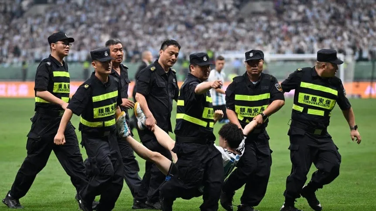 El simpatizante chino, sacado del campo por las fuerzas de seguridad. El simpatizante chino, sacado del campo por las fuerzas de seguridad.