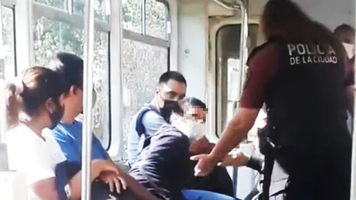 El momento en que la oficial intenta bajar al chico con autismo del premetro. Fuente:captura.
