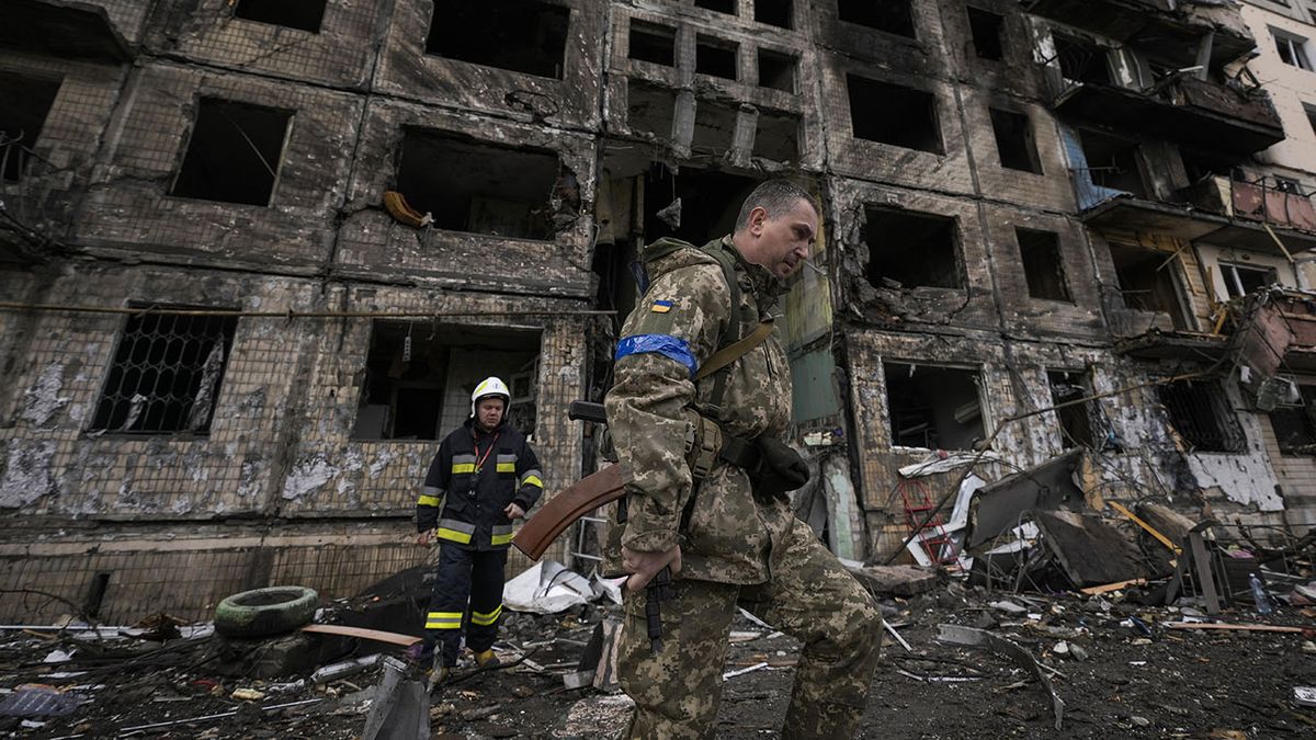 Un soldado y un bombero ucranianos examinan los restos de un edificio derruido tras un ataque ruso