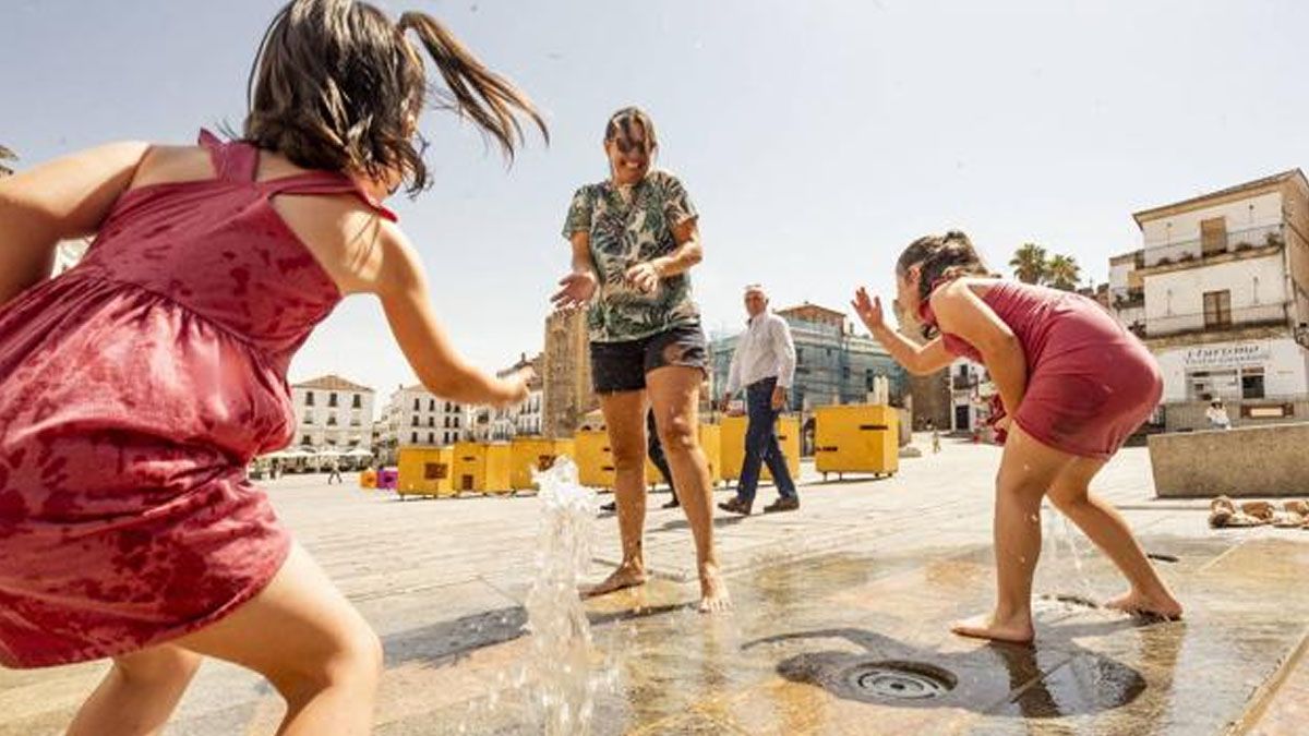 Badajoz, en Extremadura, una madre juega con sus hijas para refrescarse en el agua en una plaza c&eacute;ntrica. Con una temperatura que lleg&oacute; a 60 grados. (Foto: El diario de Extremadura)